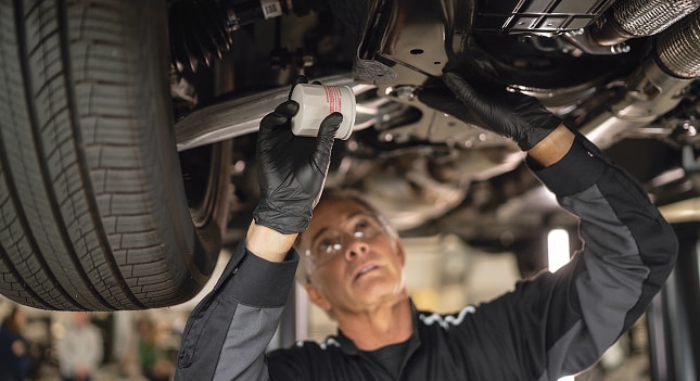 INFINITI maintenance technician changing an oil filter