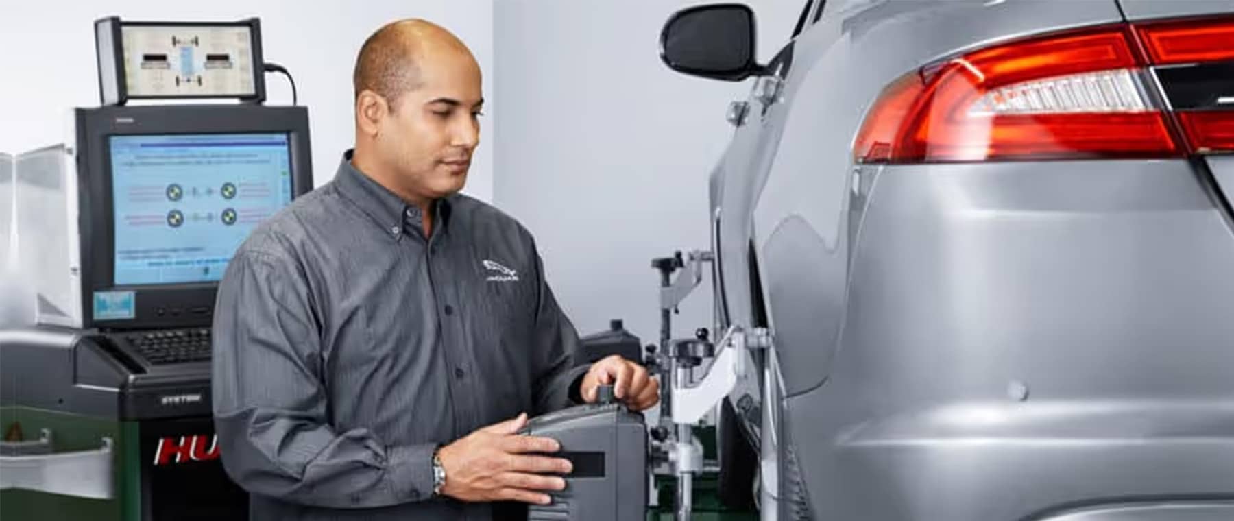 Jaguar service mechanic working on vehicle