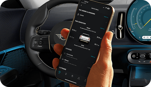 A hand holding up a phone open to the MINI App.