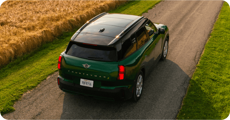Bird’s-eye view of the MINI Countryman SE ALL4 driving down a road.