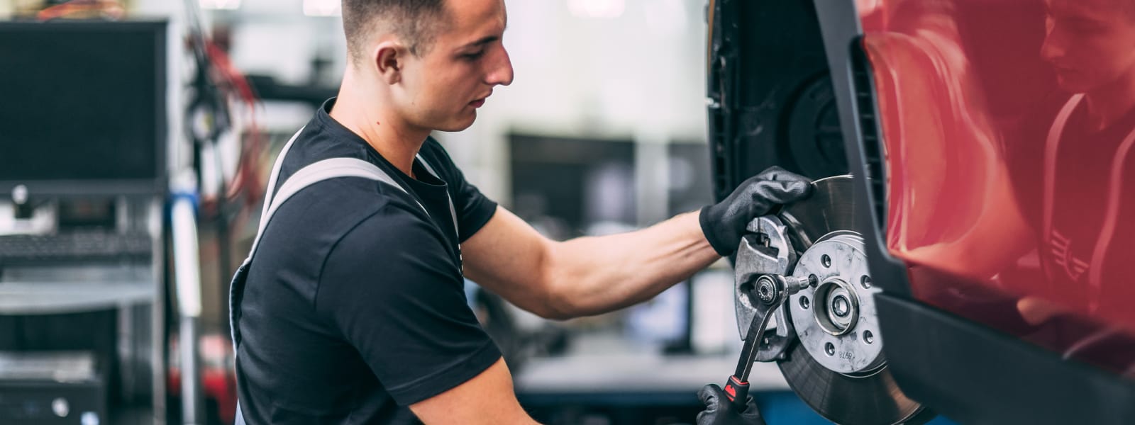 MINI Service Technician performs a brake service on a MINI vehicle on a lift in a MINI Service Facility.