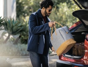 Man loading luggage into the rear of a 2022 Mazda CX-30