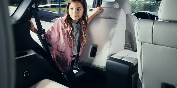 Young girl stepping into the 3rd row seating