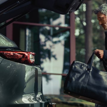 Owner loading luggage through the tail gate