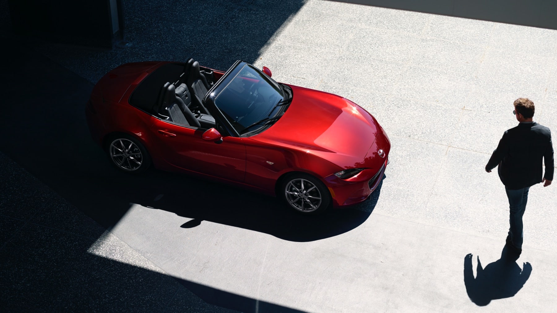 Driver approaching a red MX-5 Miata