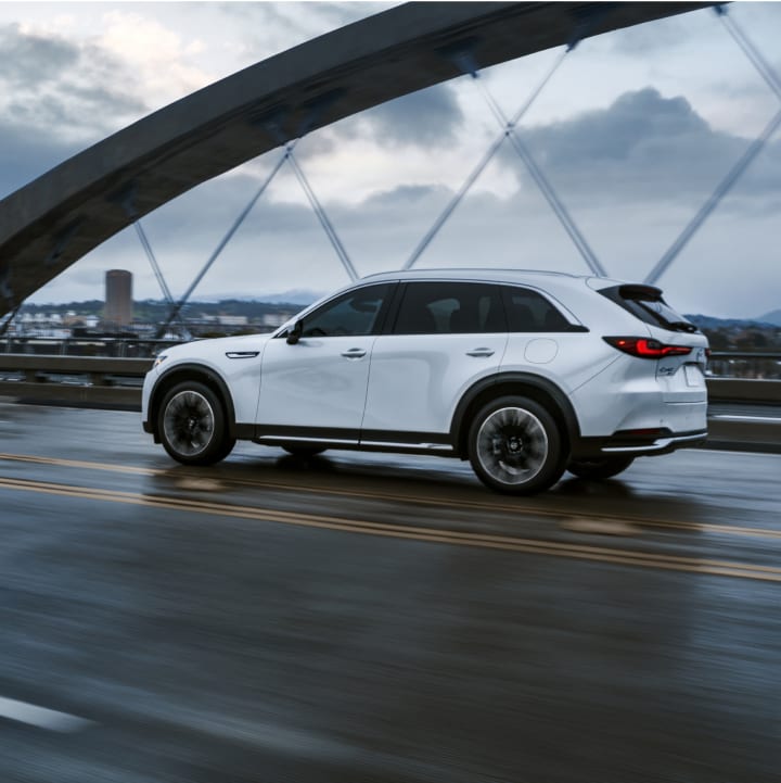 Mazda CX-90 PHEV driving across a bridge