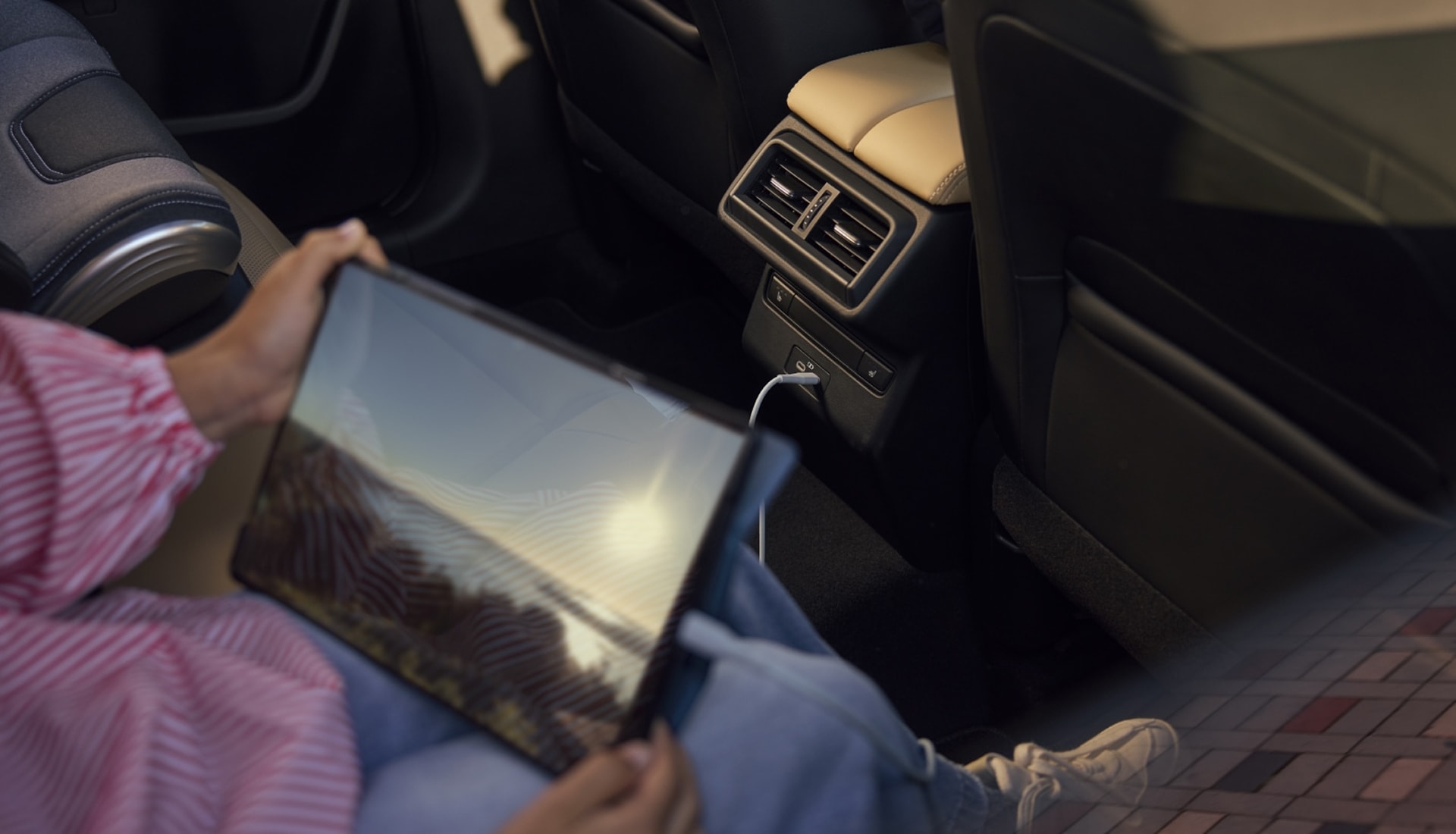 child charging a tablet in the backseat of a CX-5