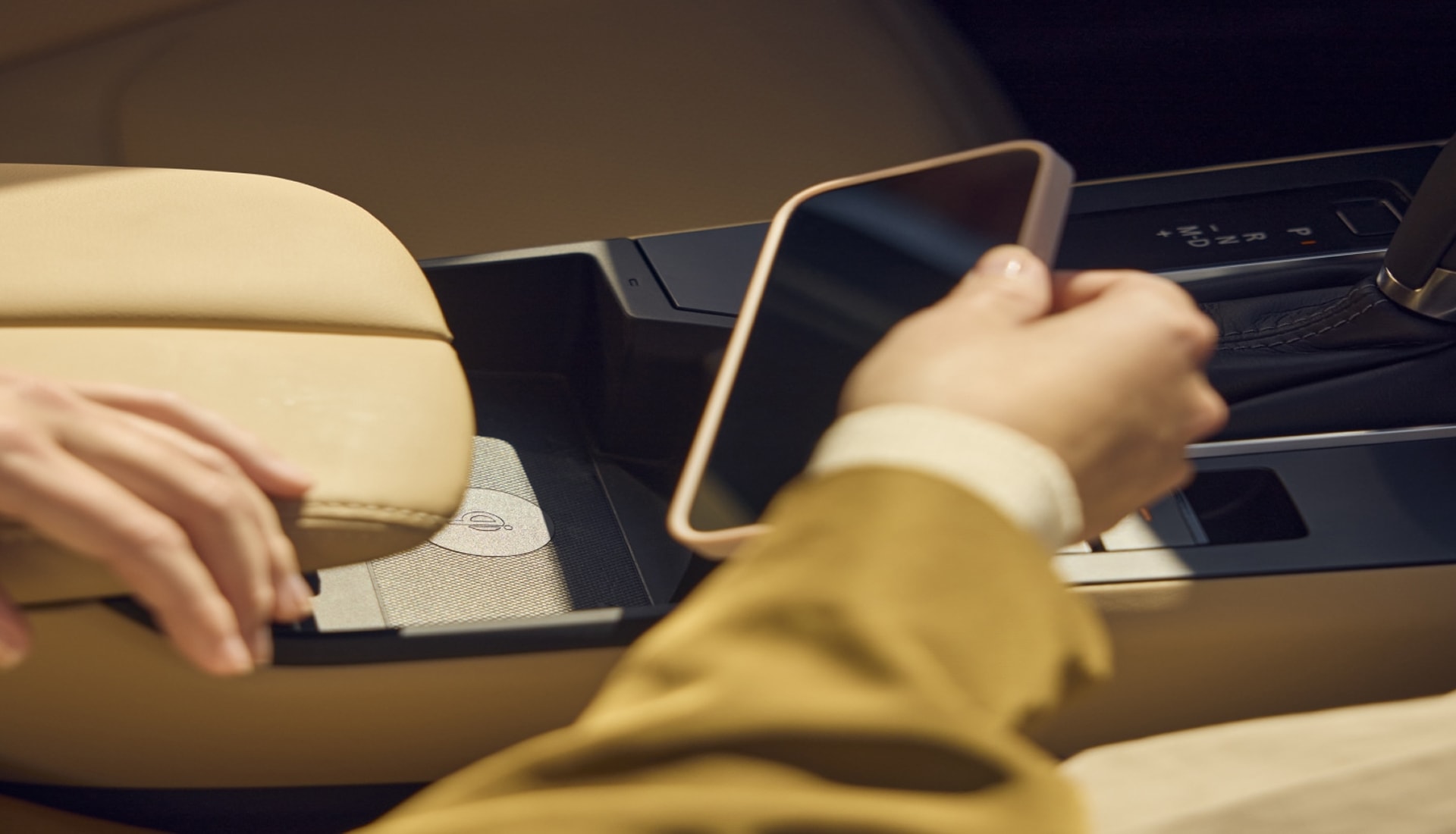 passenger using the wireless charger on a CX-5 console