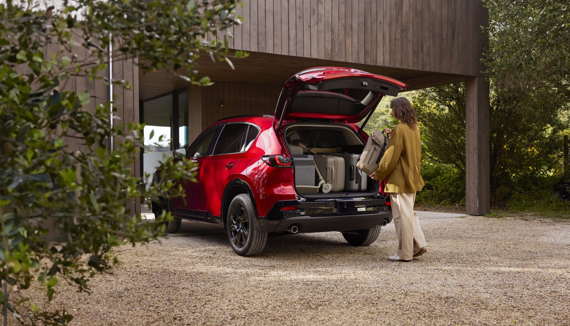 driver loading luggage into the rear of a 2026 CX-5 