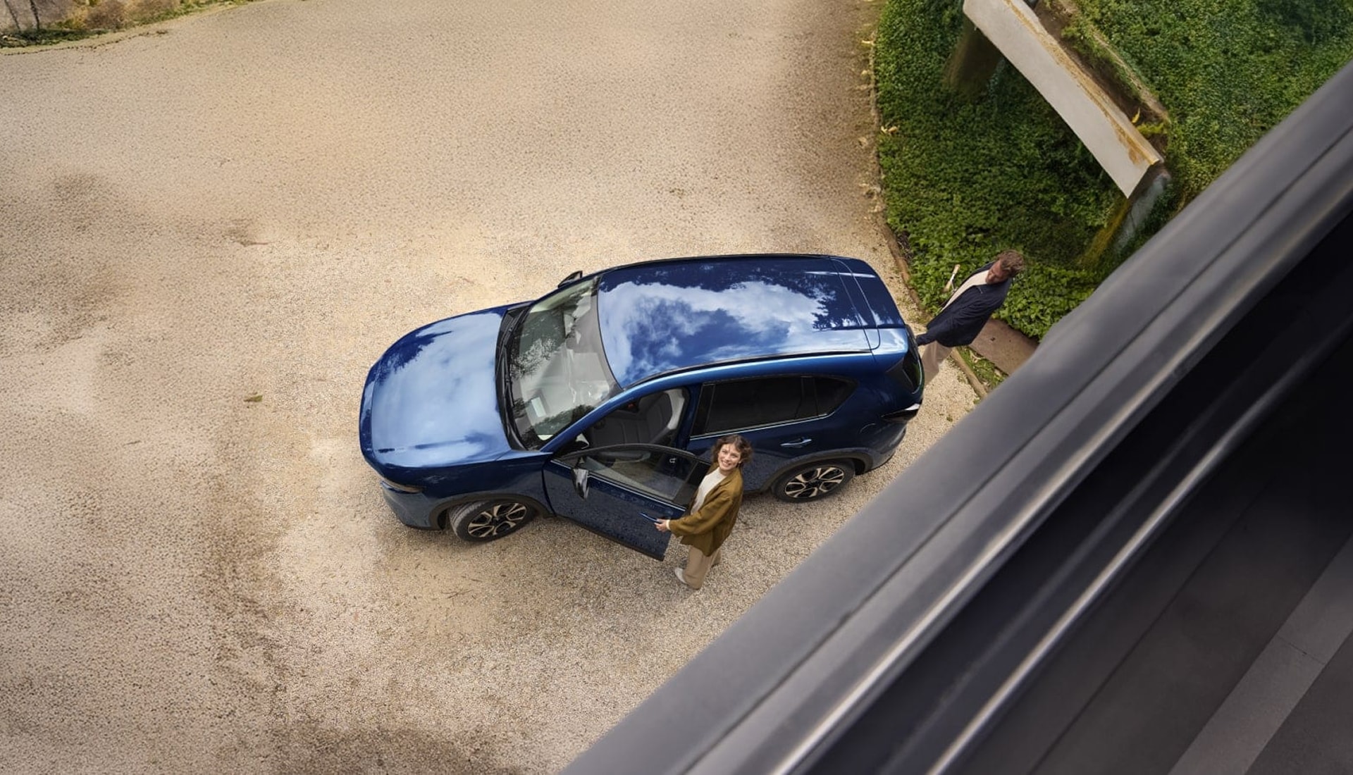 overhead view of 2 people getting into a navy blue CX-5