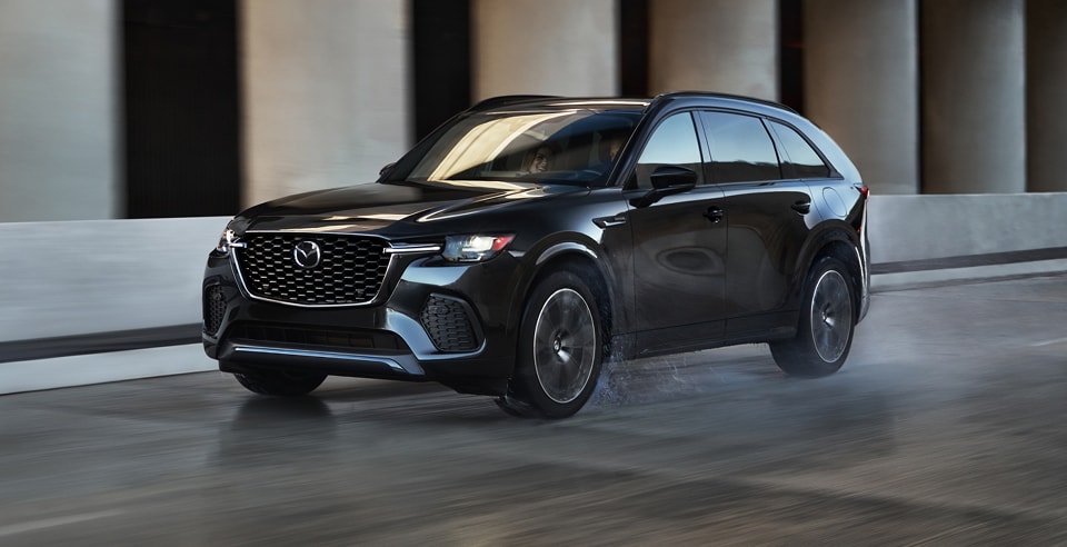 black CX-70 driving on a wet road