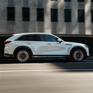 Mazda CX-90 PHEV side view driving on a city road