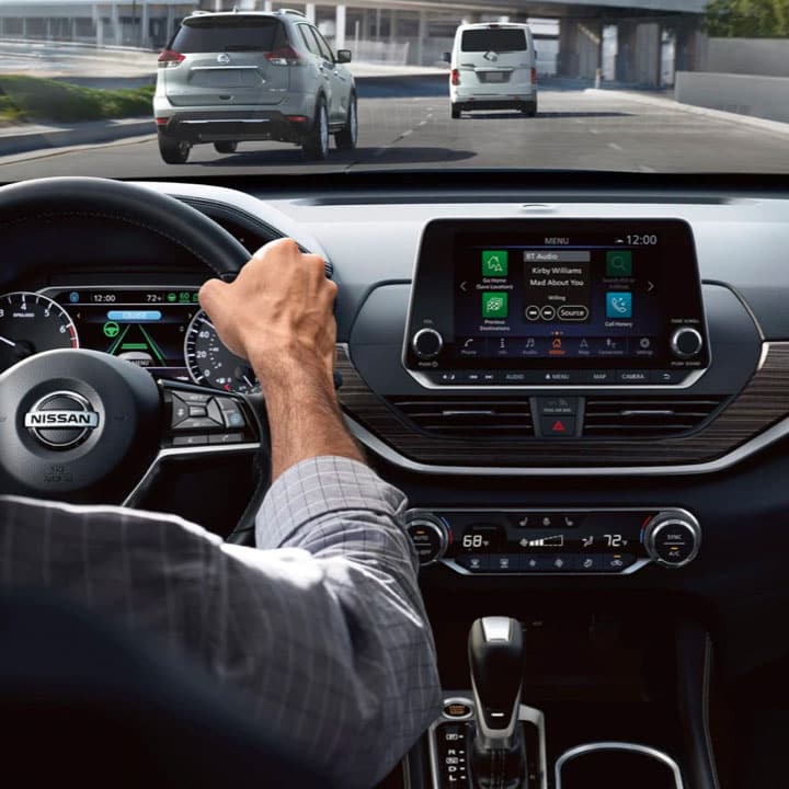 Over-the-shoulder view of man driving Nissan vehicle
