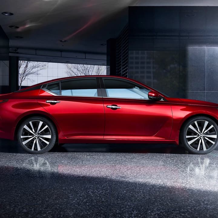 Profile view of red Nissan vehicle