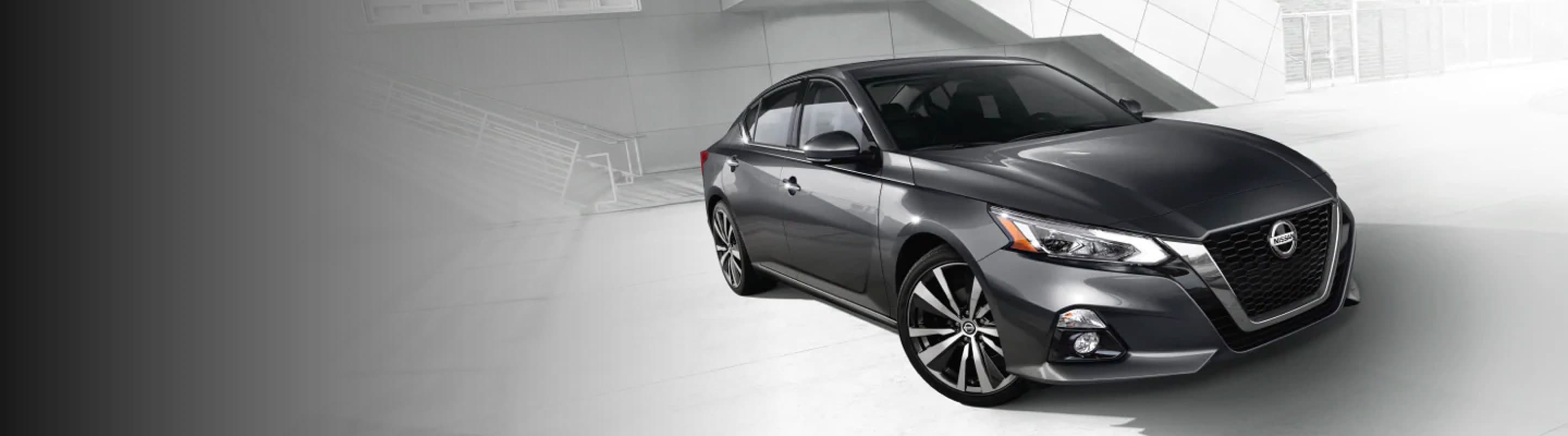 Aerial view of red Nissan Altima turning a street corner