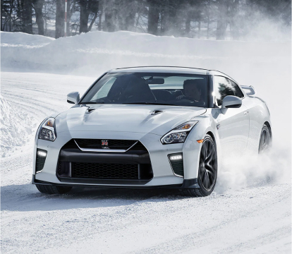 White Nissan GT-R driving down snow covered street