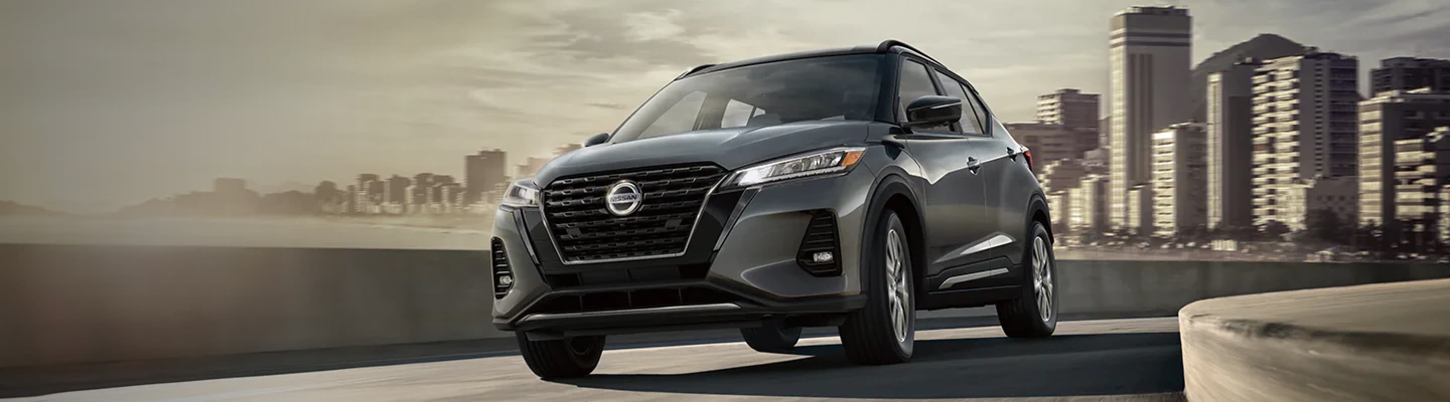 Aerial view of grey Nissan Kicks driving down a street