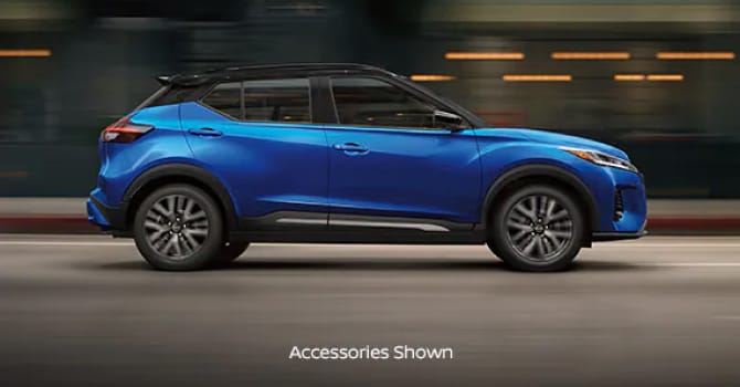 Side view of Blue Nissan Kicks driving down street