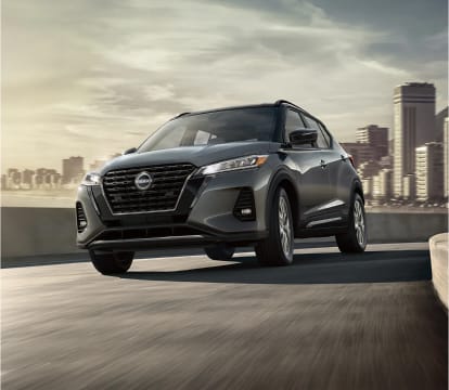 Front shot of Gray Nissan Kicks driving down a ramp