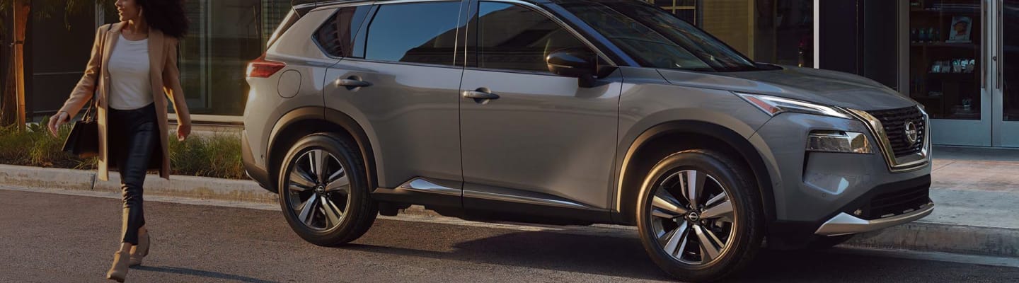 Side view of silver Nissan Rouge parked on a street