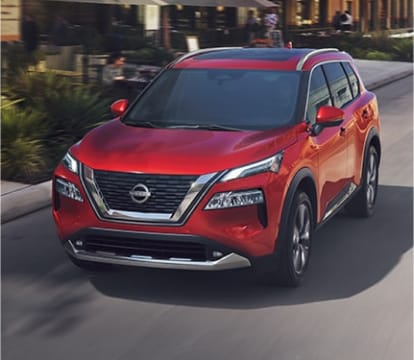 Close-up of Nissan Rouge driving down a street