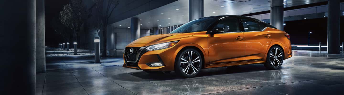 Orange Nissan Sentra parked at night