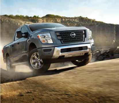 2023 Nissan Titan XD Driving up a dirt road
