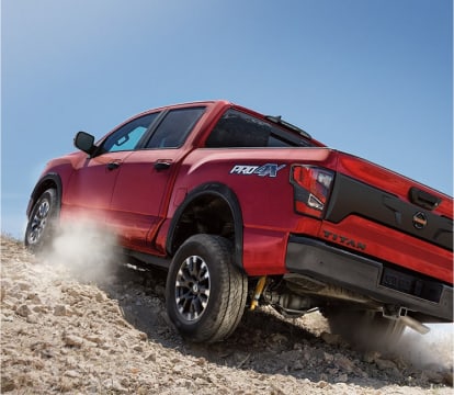 rear view of a Nissan Titan climbing a sandy hill