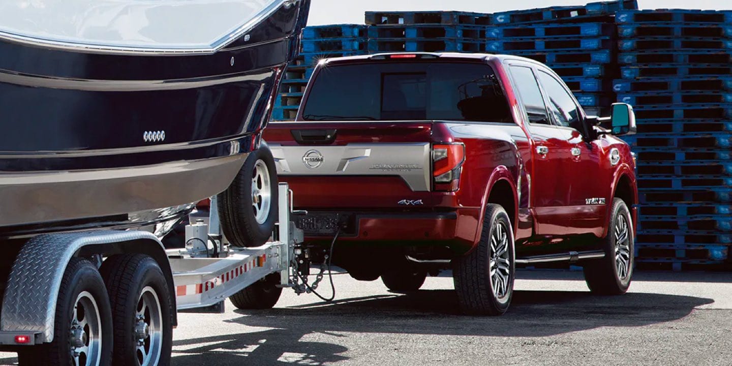 View from behind as Titan tows a large boat near some shipping pallets