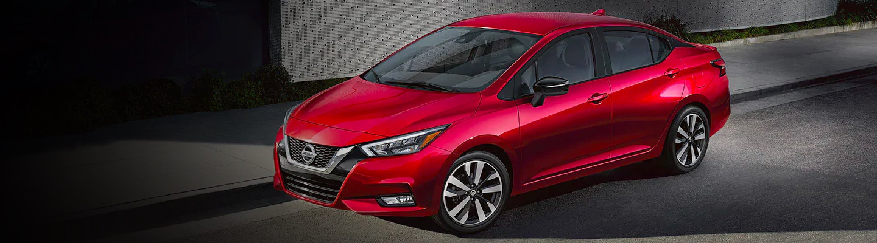 Red 2021 Nissan Versa parked on a city street