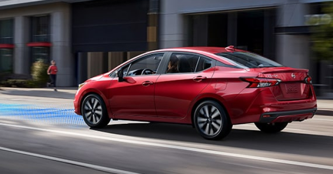 Side view of Nissan Versa driving on road