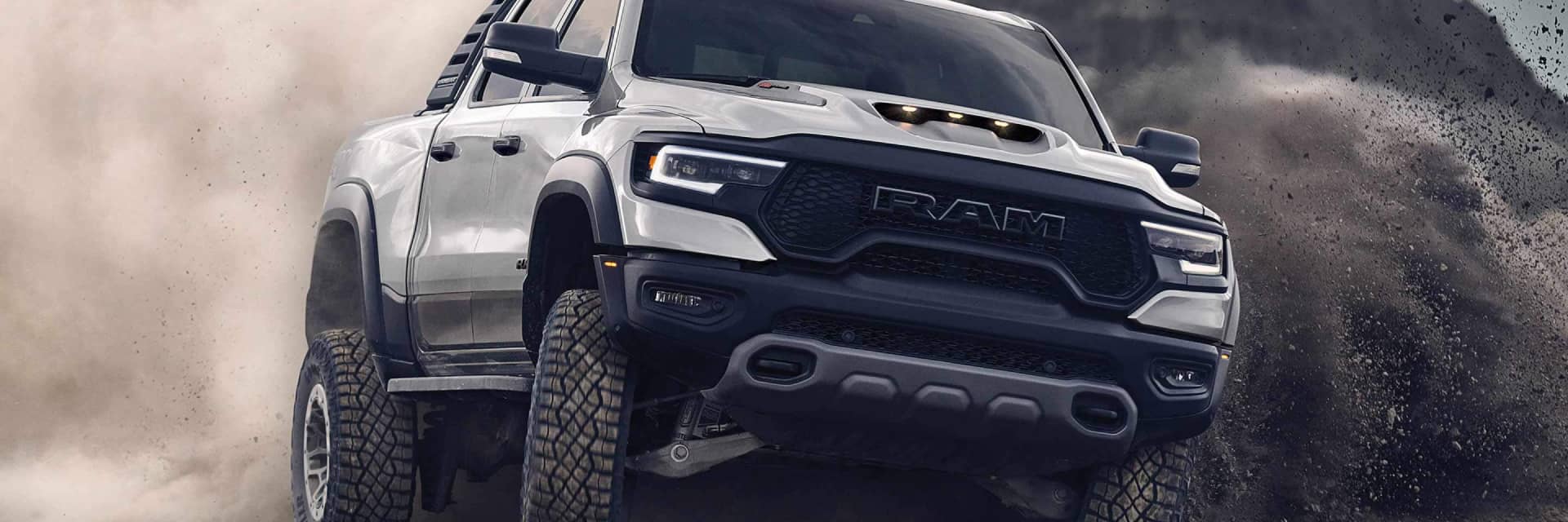 RAM-1500 kicking up dust as it turns on rocky terrain