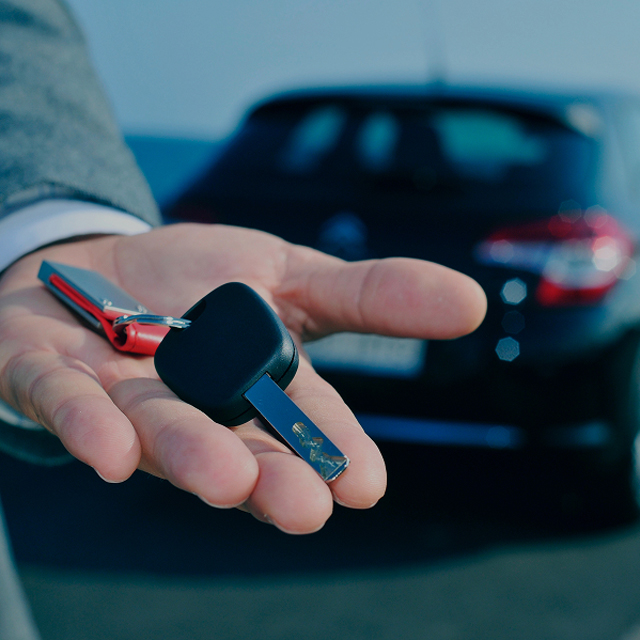 Hand holding keys to a vehicle