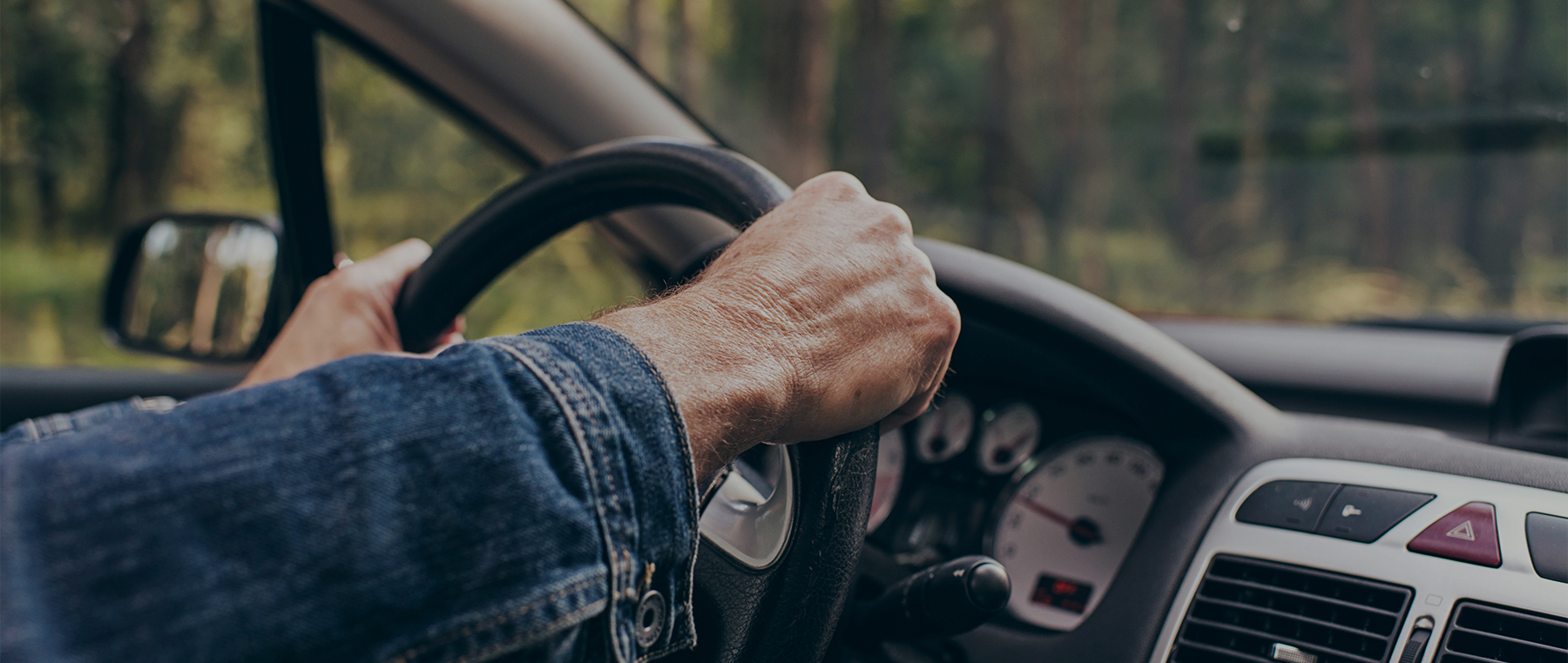 Person holding steering wheel inside vehicle