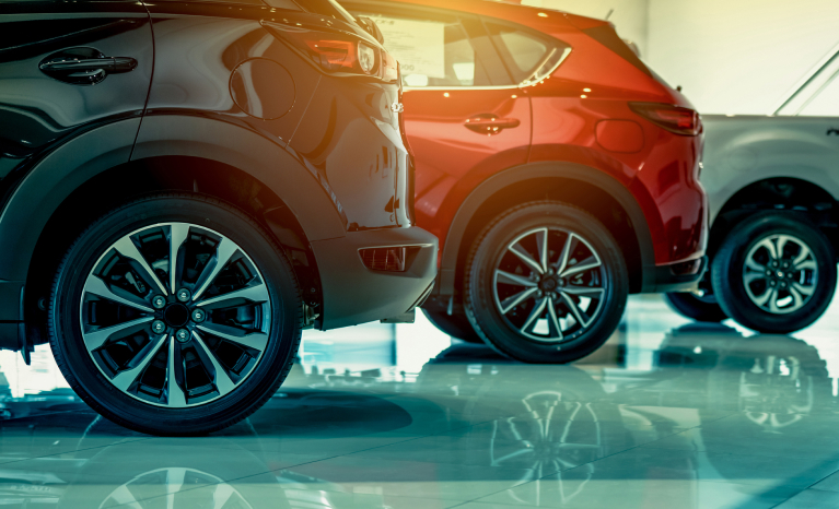 Close up of the wheels on three vehicles parked in a line