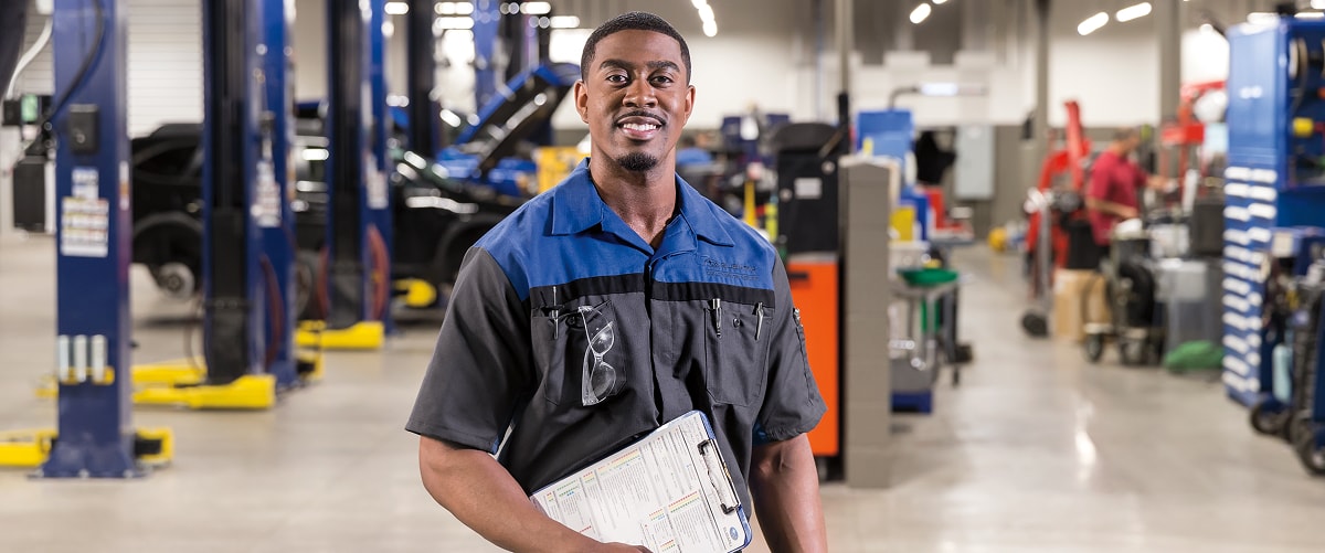 Picture of a Subaru service technician with a clipboard in a Subaru service garage
