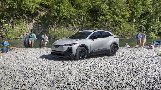 A static image of Uncharted Sport in Metropolis Gray Metallic parked on a rocky bank of a river. 