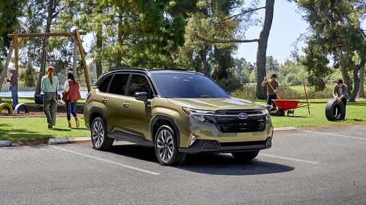 A Subaru Forester Hybrid parked in a sunny park lot near a playground.