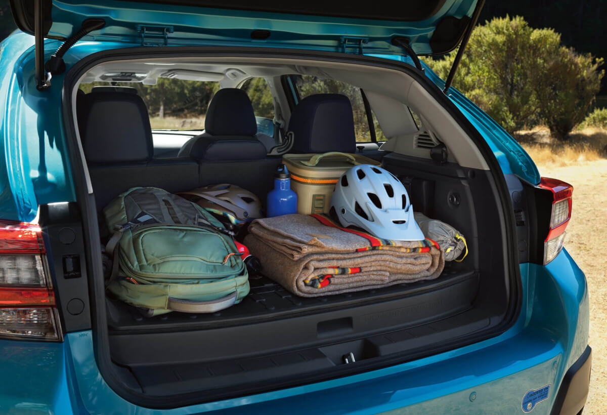 A backpack, blanket, and bike helmet in the rear cargo area of a Crosstrek Hybrid