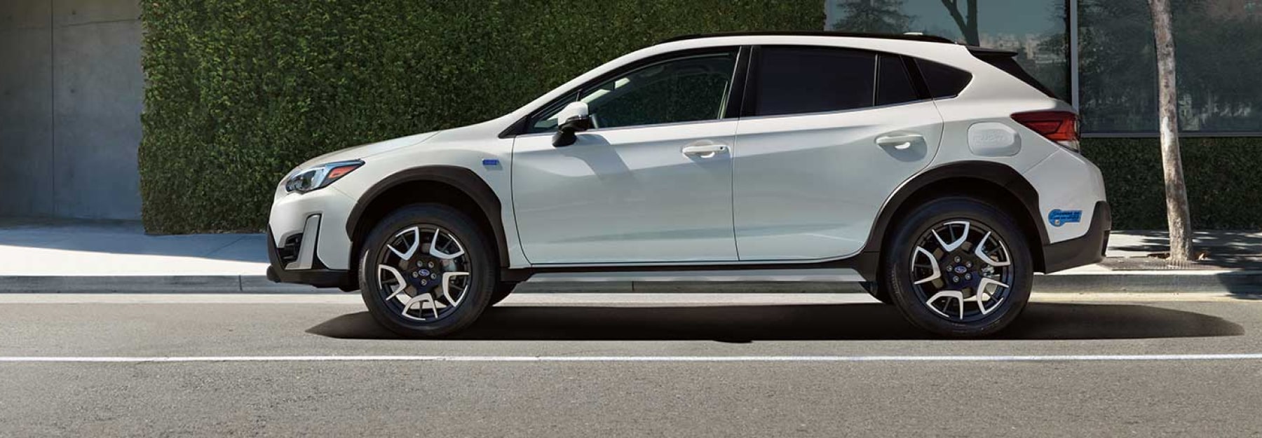 The side profile of a white Subaru Crosstrek Hybrid
