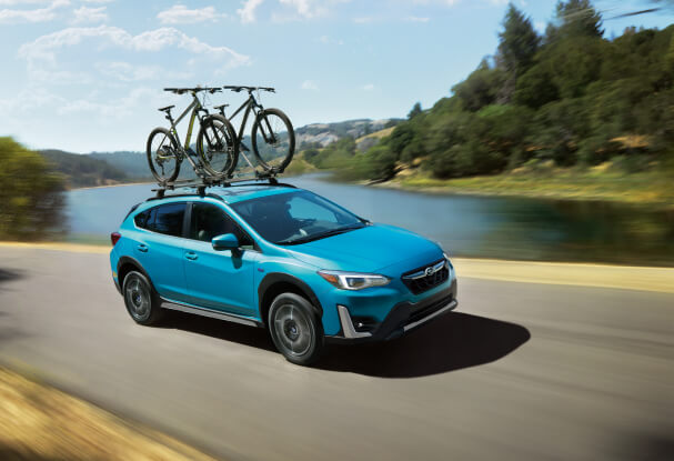 A 2023 Crosstrek Hybrid driving on a highway.