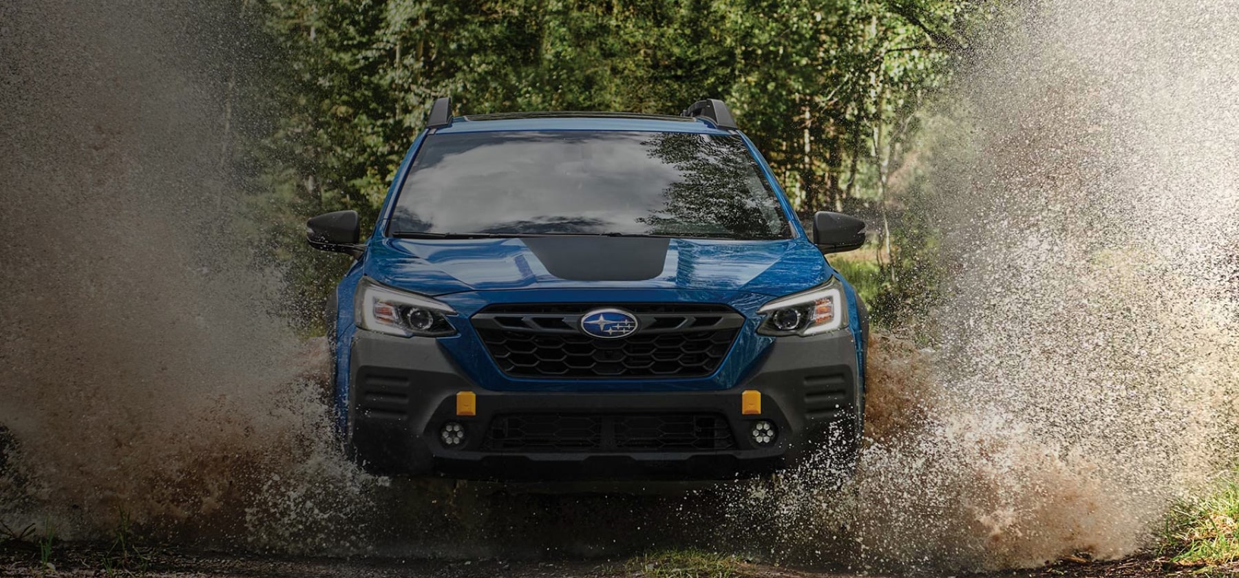 2022 Subaru Outback Wilderness driving through mud.