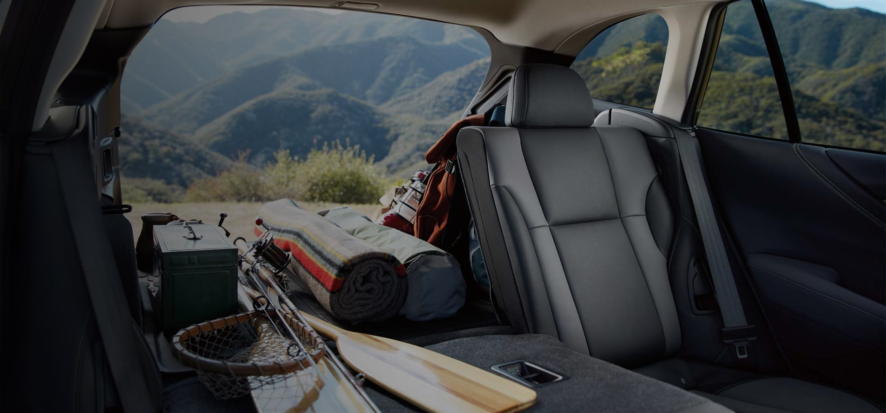 A view from inside the 2022 Subaru Outback showing the cargo area filled with outdoor gear and part of the rear seat folded down.