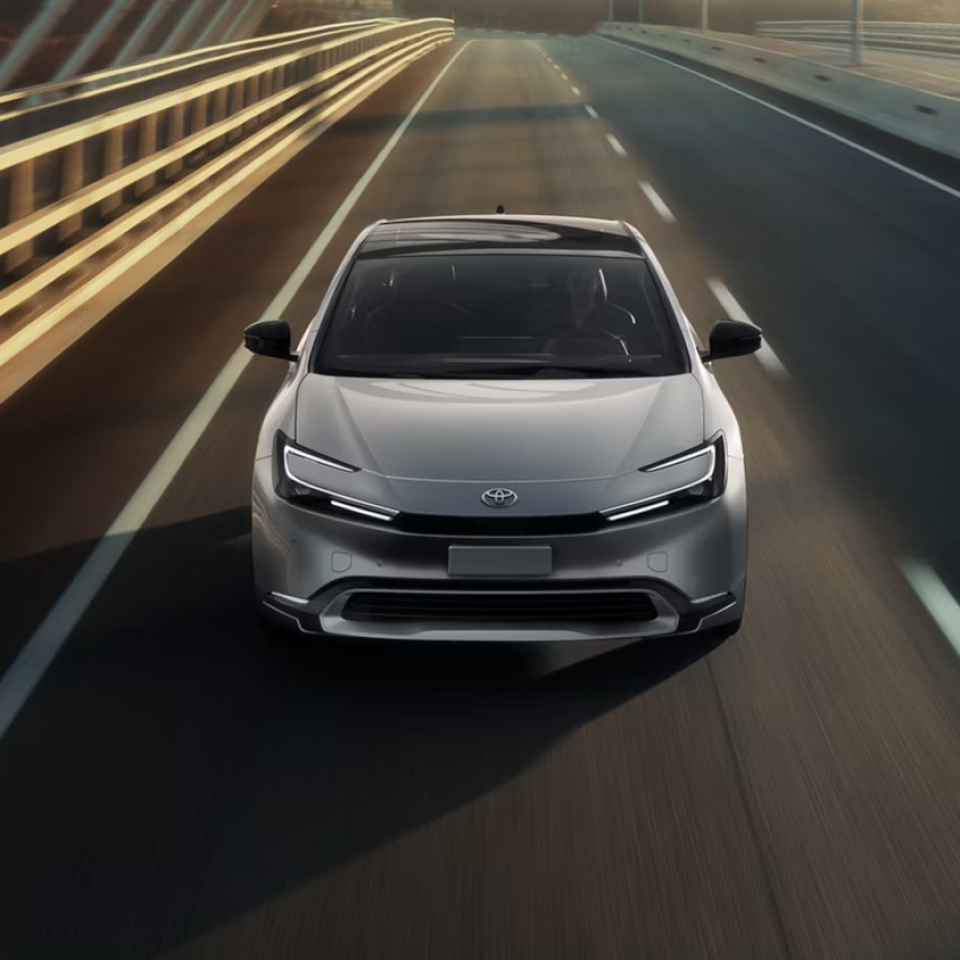 2027 Prius driving on road towards viewer