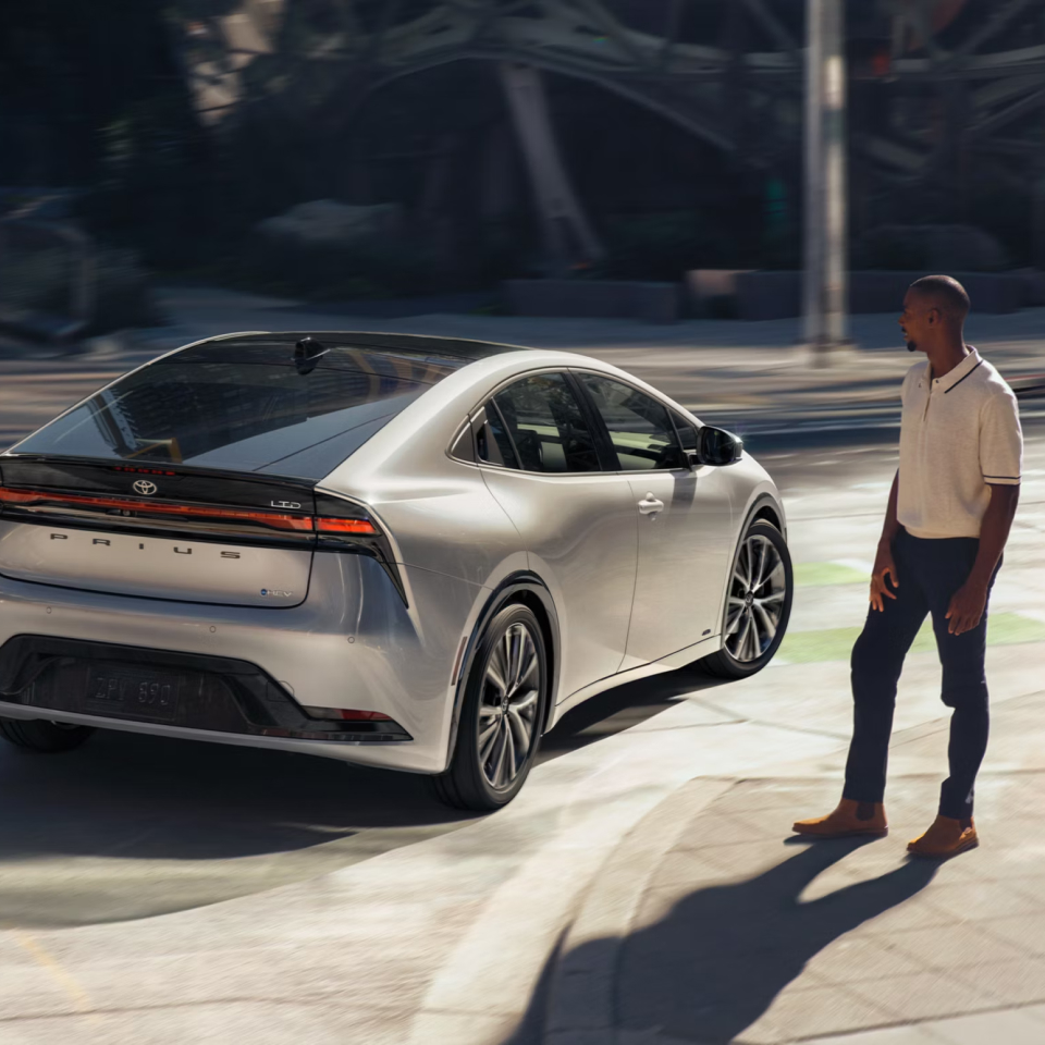 2027 Prius near a curbside and person walking towards it