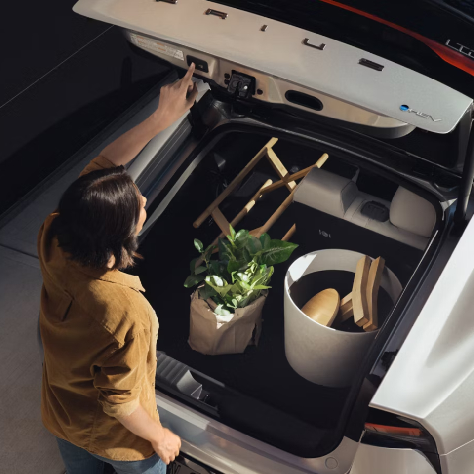 Person opening trunk showing large items stored in trunk space