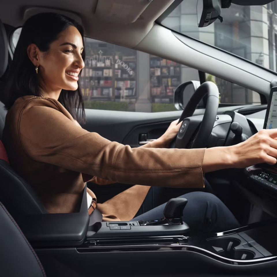 Smiling person in driver's seat making selections on digital display