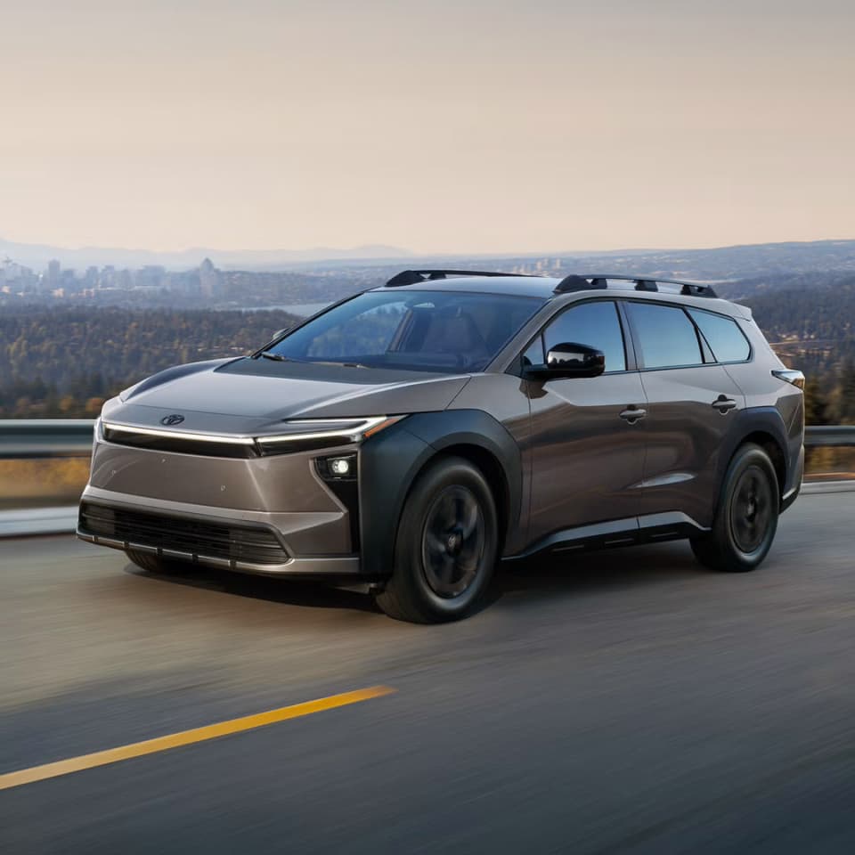2027 Toyota bZ Woodland driving down a road in motion