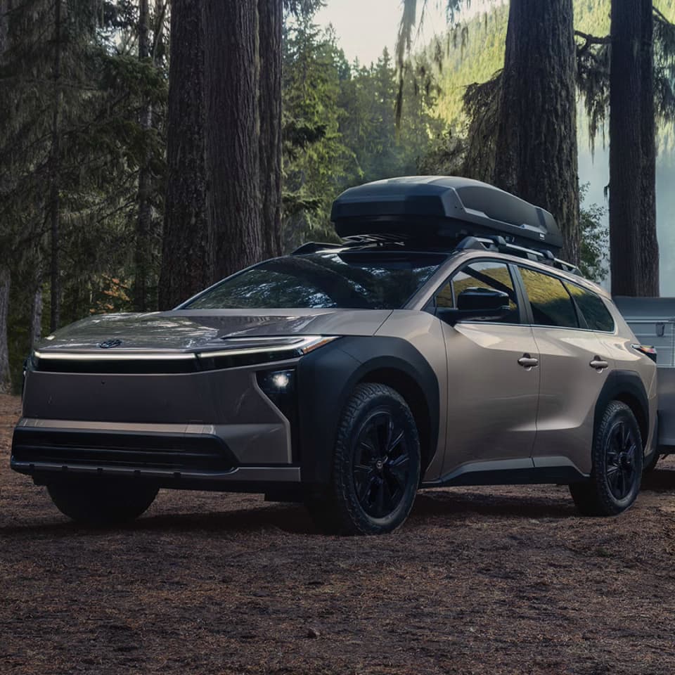 2027 Toyota bZ Woodland with roof cargo parked in a forest
