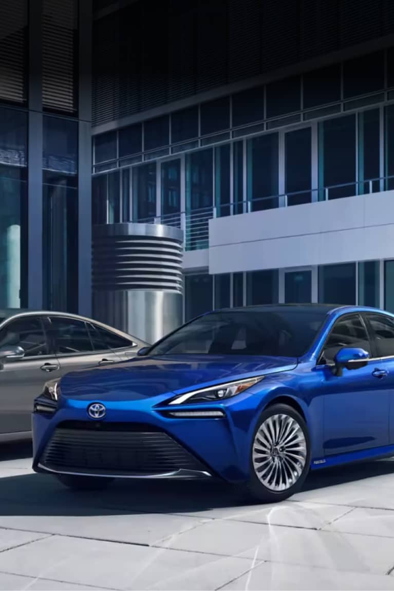 Blue Toyota sedan parked in front of an office building